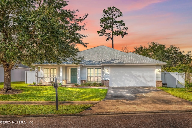 view of front of house featuring a garage and a lawn