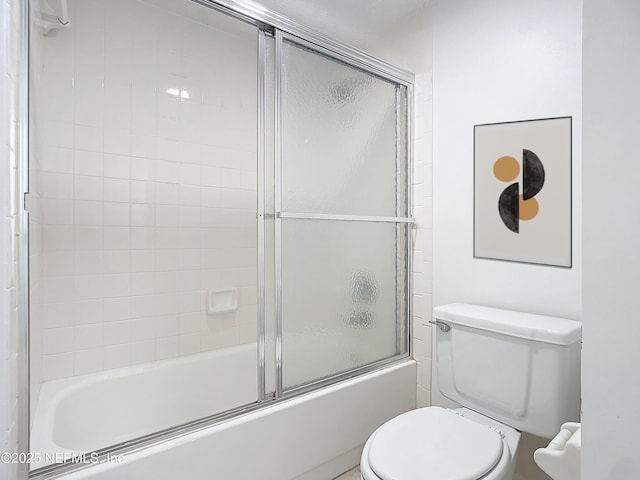 bathroom with combined bath / shower with glass door and toilet