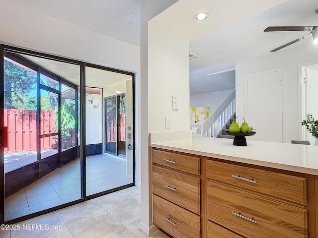 interior space with light tile patterned flooring, ceiling fan, and a textured ceiling