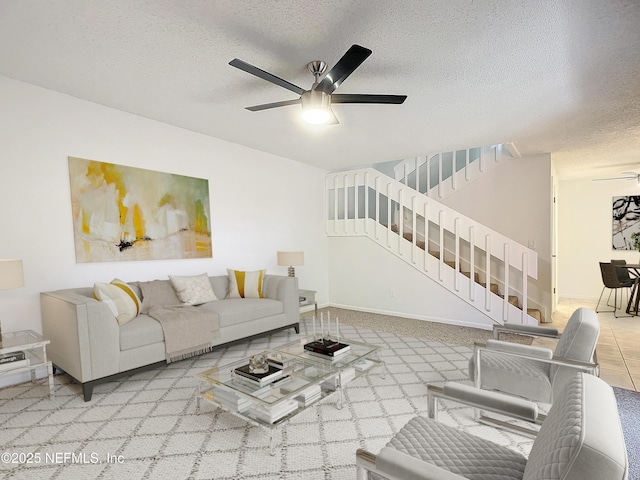 living room with a textured ceiling and ceiling fan