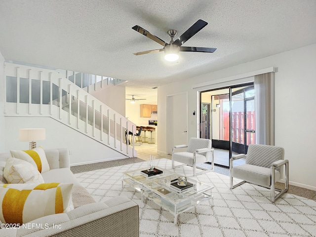 carpeted living room featuring ceiling fan and a textured ceiling