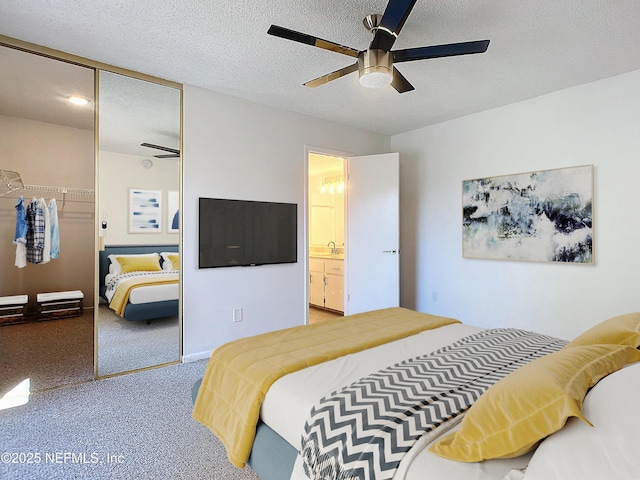 carpeted bedroom with ensuite bathroom, sink, a textured ceiling, a closet, and ceiling fan