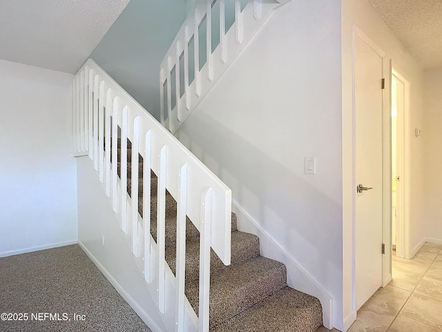 stairway with a textured ceiling