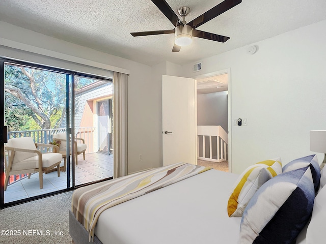 bedroom with access to outside, light colored carpet, and a textured ceiling