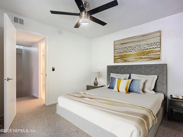 carpeted bedroom with ceiling fan and a textured ceiling