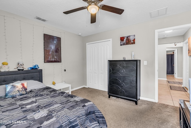 carpeted bedroom featuring ceiling fan, a textured ceiling, and a closet