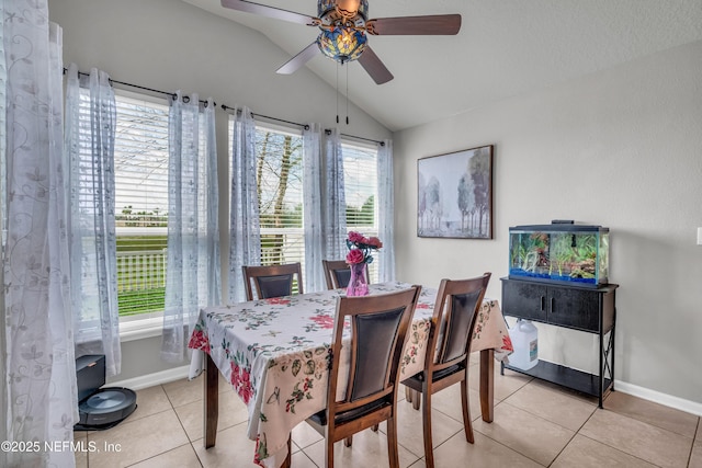 tiled dining room with lofted ceiling and ceiling fan