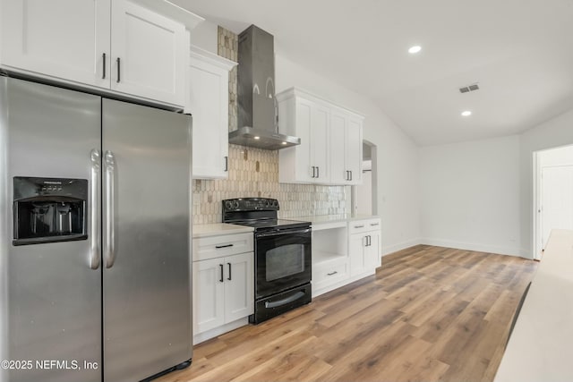 kitchen with white cabinetry, electric range, stainless steel refrigerator with ice dispenser, vaulted ceiling, and wall chimney exhaust hood