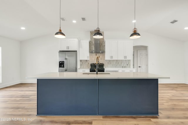 kitchen with white cabinets, stainless steel fridge, and a spacious island