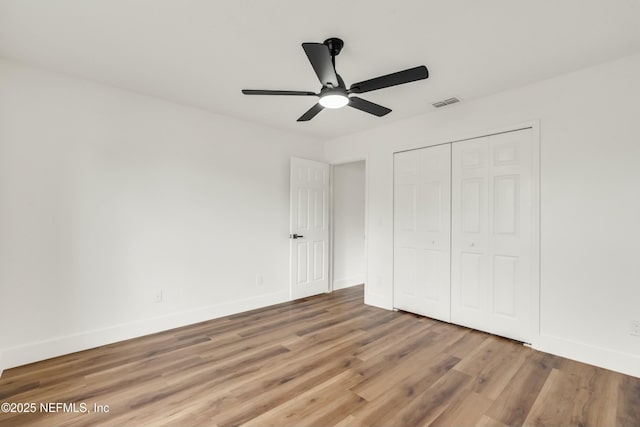 unfurnished bedroom with ceiling fan, hardwood / wood-style floors, and a closet