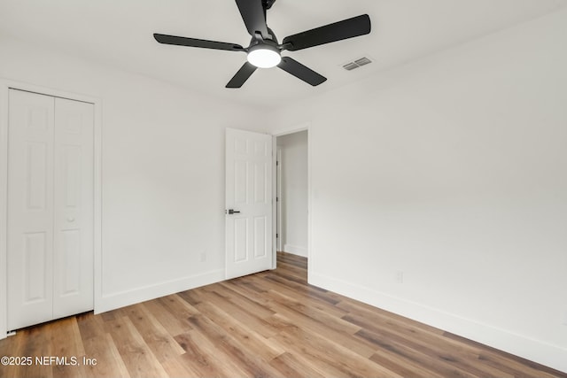 unfurnished bedroom with ceiling fan, light hardwood / wood-style floors, and a closet