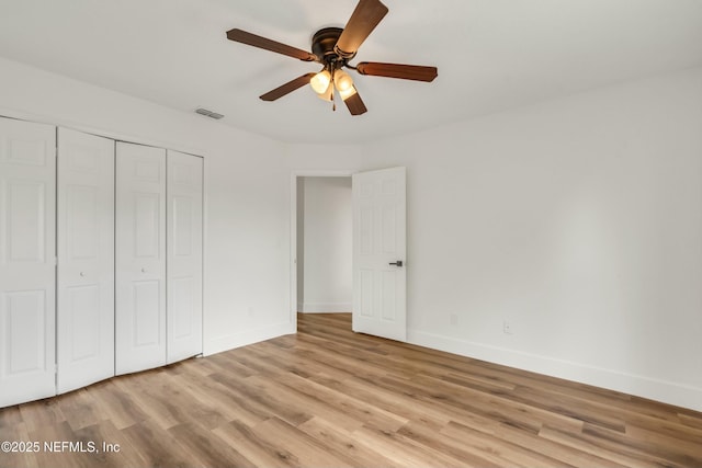 unfurnished bedroom with ceiling fan, light hardwood / wood-style floors, and a closet