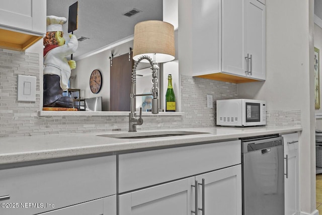 kitchen with sink, stainless steel dishwasher, and white cabinets