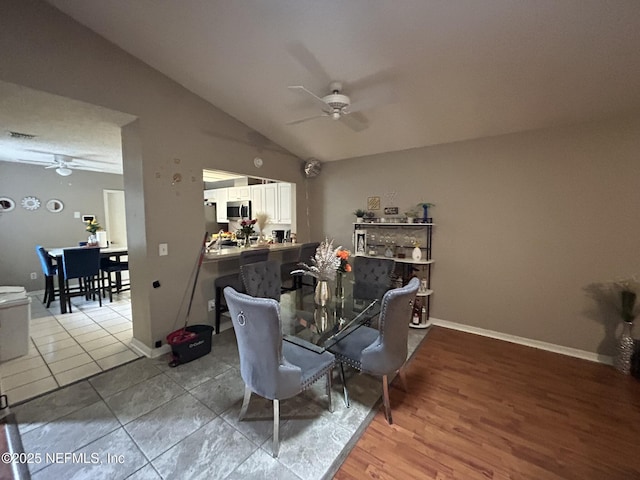 tiled dining area with vaulted ceiling and ceiling fan