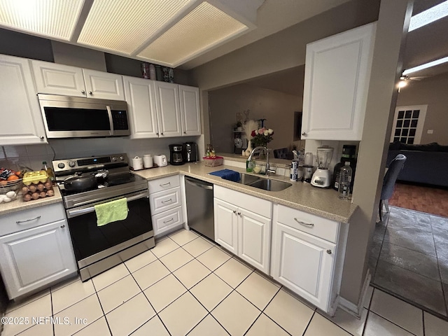 kitchen with sink, decorative backsplash, white cabinets, and appliances with stainless steel finishes