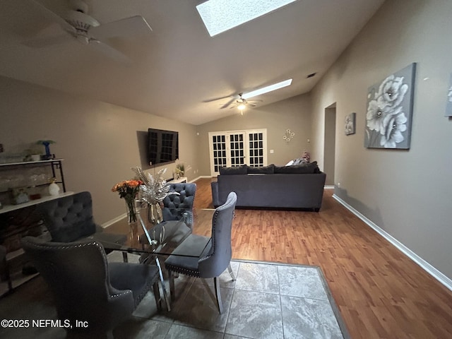 dining space with ceiling fan, wood-type flooring, and lofted ceiling with skylight