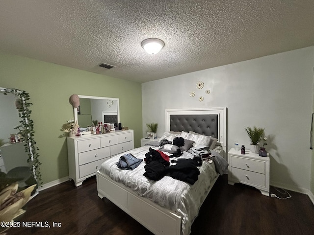 bedroom featuring a textured ceiling and dark hardwood / wood-style flooring