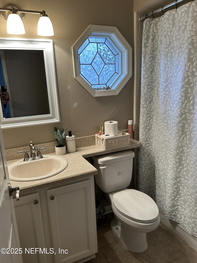 bathroom featuring vanity, toilet, and curtained shower