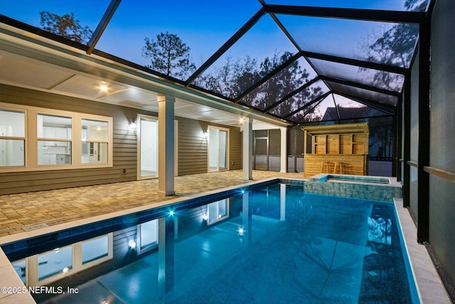 85158 Southern Creek Blvd, Fernandina Beach, FL 32034 - pool at dusk featuring an in ground hot tub, a patio, and a lanai