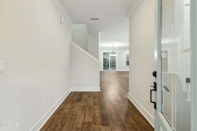 85158 Southern Creek Blvd, Fernandina Beach, FL 32034 - hallway featuring a notable chandelier, ornamental molding, and dark wood-type flooring