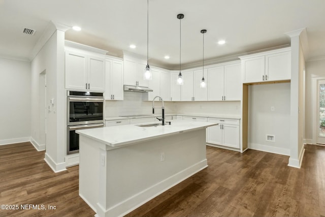 85158 Southern Creek Blvd, Fernandina Beach, FL 32034 - kitchen featuring double oven, white cabinetry, a kitchen island with sink, and crown molding