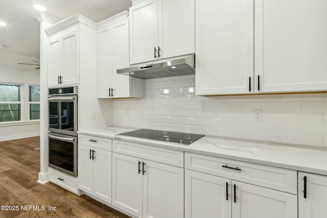 85158 Southern Creek Blvd, Fernandina Beach, FL 32034 - kitchen featuring stainless steel double oven, light stone countertops, black electric stovetop, dark wood-type flooring, and white cabinets