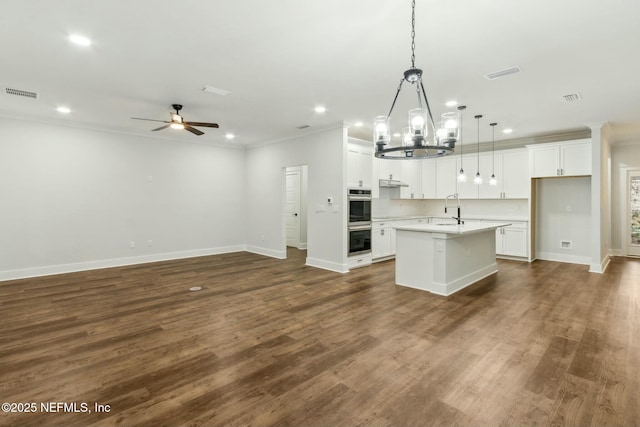 85158 Southern Creek Blvd, Fernandina Beach, FL 32034 - kitchen featuring a center island with sink, decorative light fixtures, sink, white cabinets, and double oven