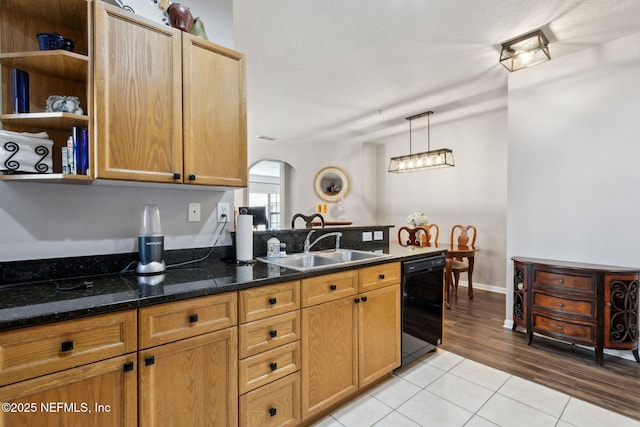kitchen featuring arched walkways, light tile patterned flooring, a sink, dishwasher, and open shelves