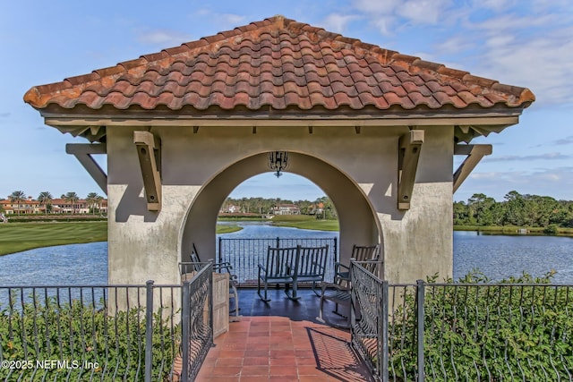 view of community featuring a water view and fence