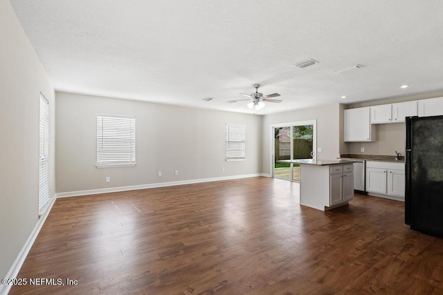 kitchen with dark wood-type flooring, white cabinetry, black refrigerator, dishwasher, and a kitchen island