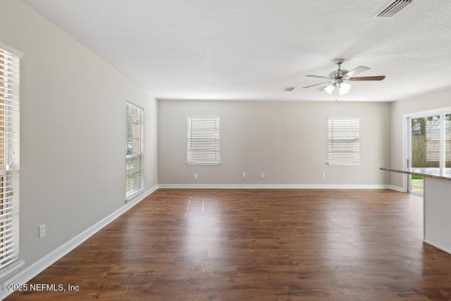 empty room featuring ceiling fan, dark hardwood / wood-style flooring, and a textured ceiling