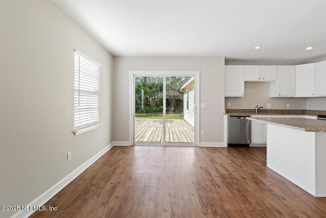 kitchen with white cabinets, dark wood-type flooring, dishwasher, and stone countertops