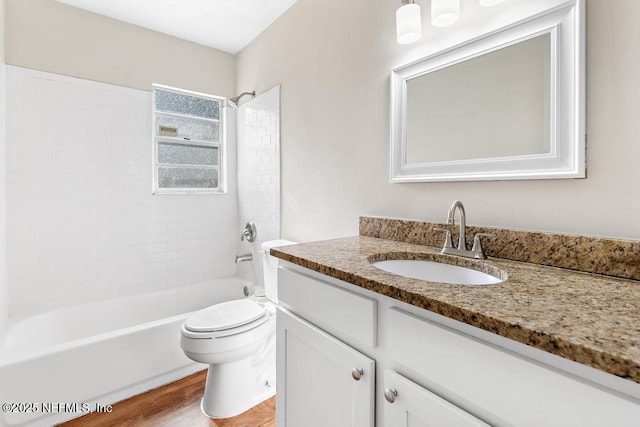 full bathroom featuring vanity, tiled shower / bath, wood-type flooring, and toilet