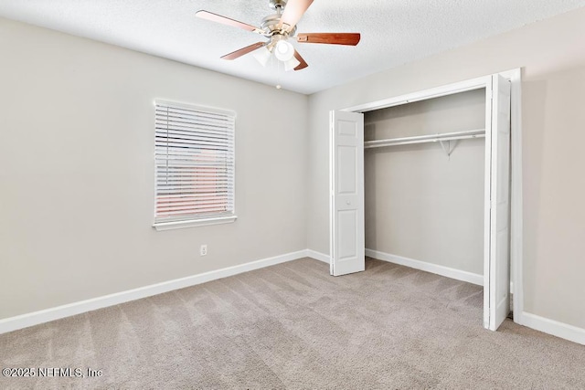 unfurnished bedroom with ceiling fan, a closet, light carpet, and a textured ceiling