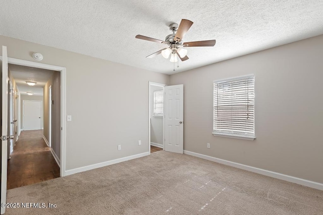 unfurnished bedroom with ceiling fan, a textured ceiling, and carpet flooring