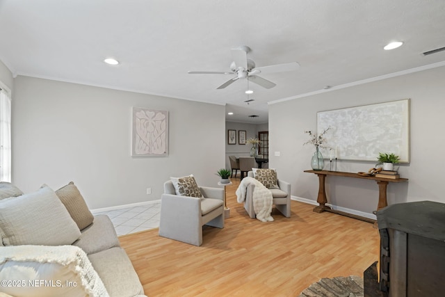 living room featuring hardwood / wood-style flooring, ornamental molding, and ceiling fan