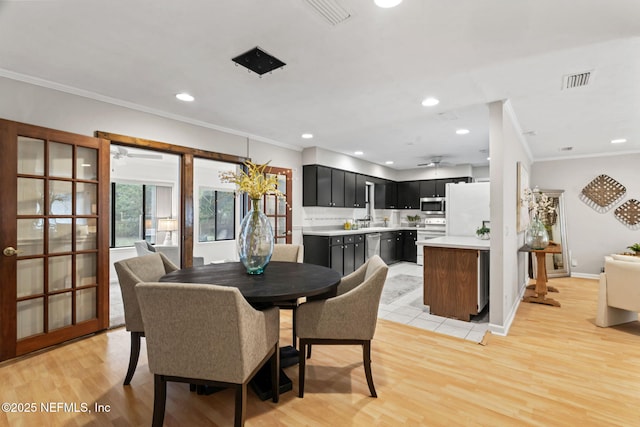 dining room featuring ornamental molding and light hardwood / wood-style floors