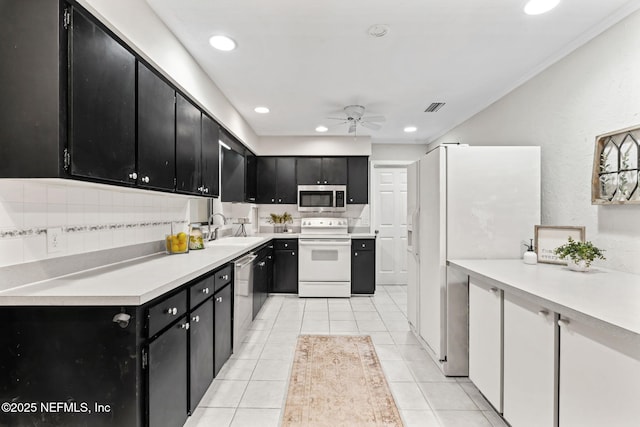 kitchen with light tile patterned flooring, sink, ceiling fan, stainless steel appliances, and backsplash