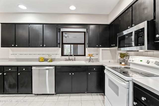 kitchen featuring sink, decorative backsplash, stainless steel appliances, and light tile patterned flooring