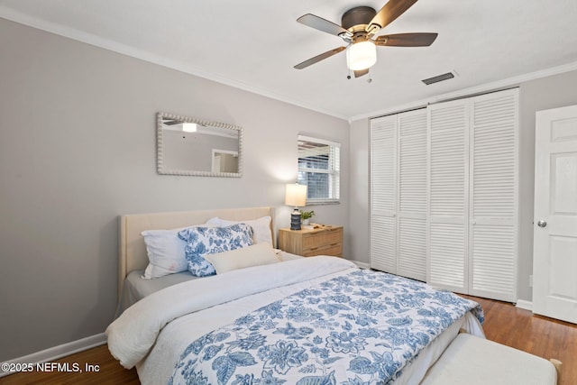 bedroom featuring a closet, crown molding, dark hardwood / wood-style floors, and ceiling fan