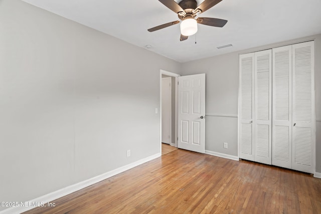 unfurnished bedroom featuring ceiling fan, light wood-type flooring, and a closet