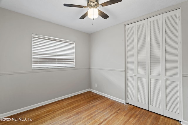 unfurnished bedroom with hardwood / wood-style floors, a closet, and ceiling fan