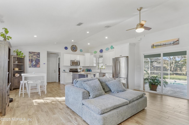 living area with light wood-style floors, recessed lighting, vaulted ceiling, and a ceiling fan