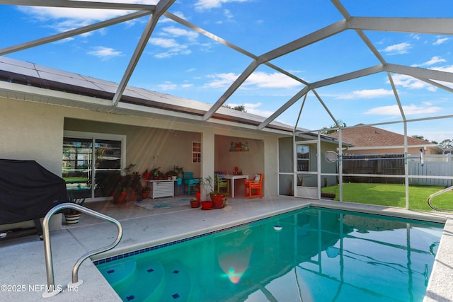 view of swimming pool with glass enclosure, fence, a lawn, a fenced in pool, and a patio area