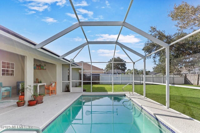 view of pool with glass enclosure, a fenced backyard, a patio, and a yard