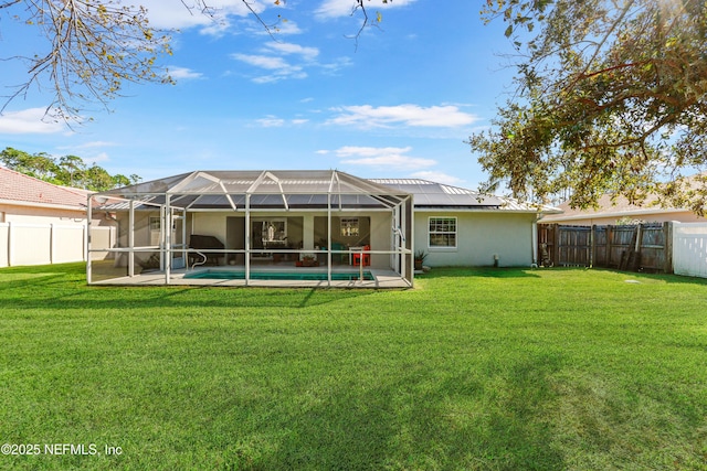 back of house featuring a fenced in pool, glass enclosure, a yard, and a fenced backyard