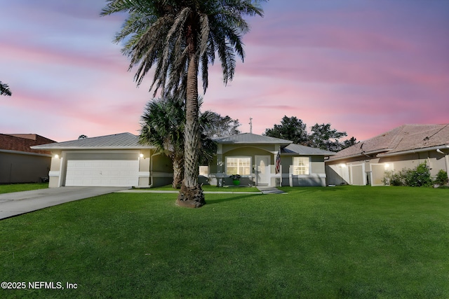 view of front facade featuring a garage, metal roof, a front lawn, and concrete driveway