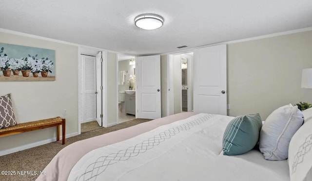 bedroom featuring ensuite bath, visible vents, baseboards, and carpet floors