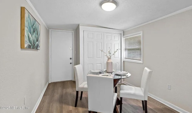 dining room featuring wood finished floors, baseboards, and a textured ceiling