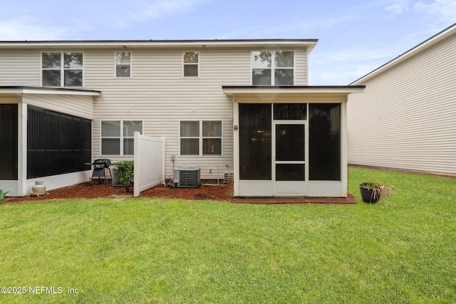 back of property featuring central AC unit, a lawn, and a sunroom